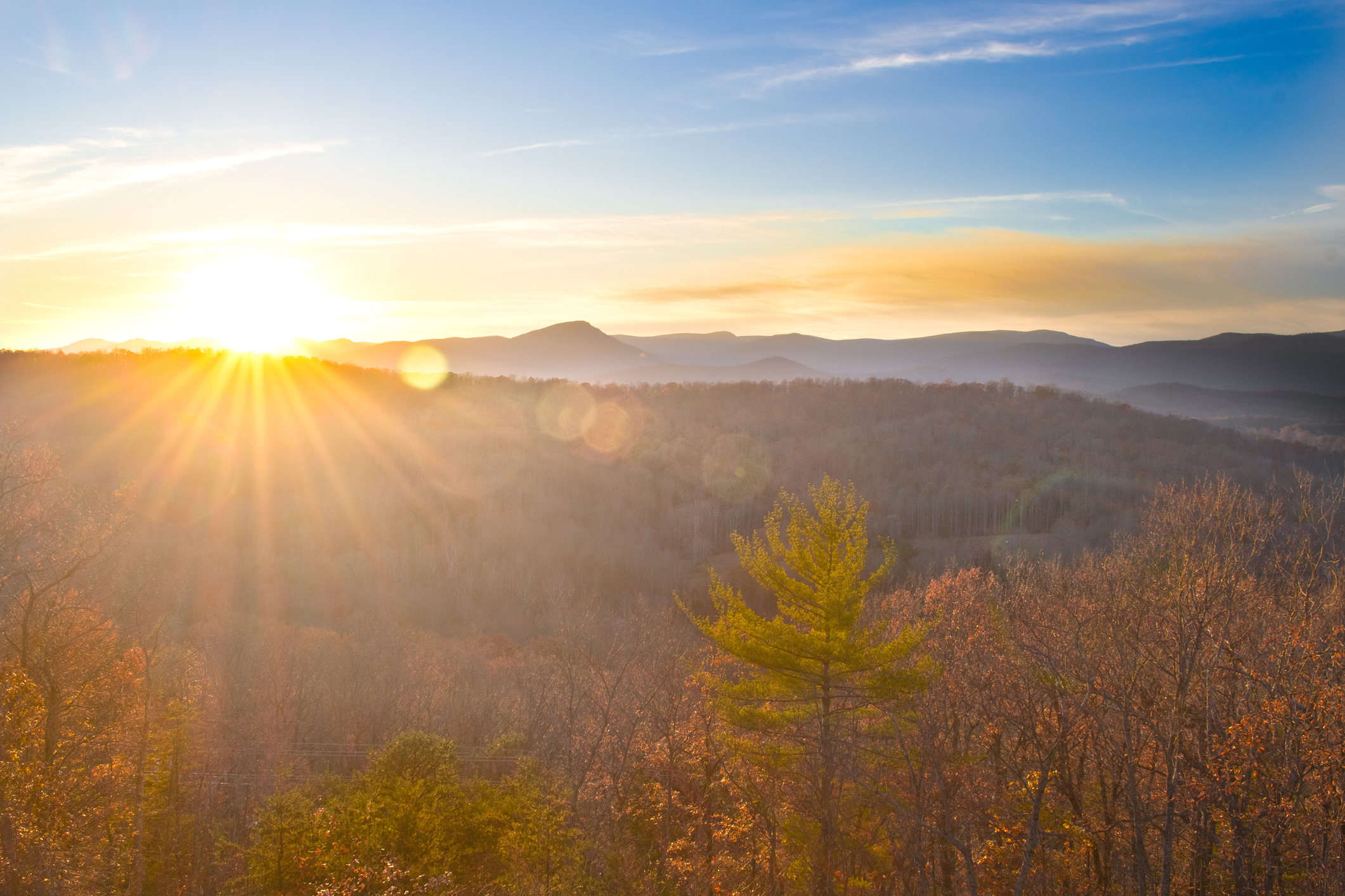 An image of a sunset behind a Virginia mountain range in the fall.